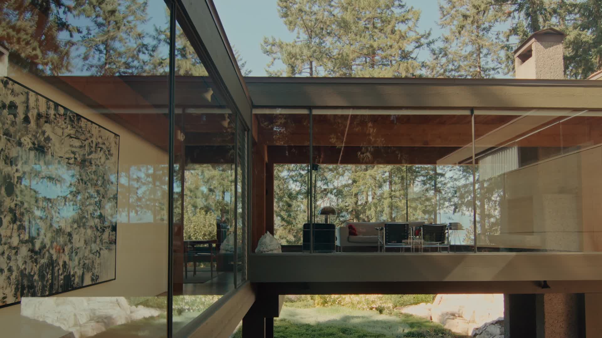 A glass-walled house set among trees