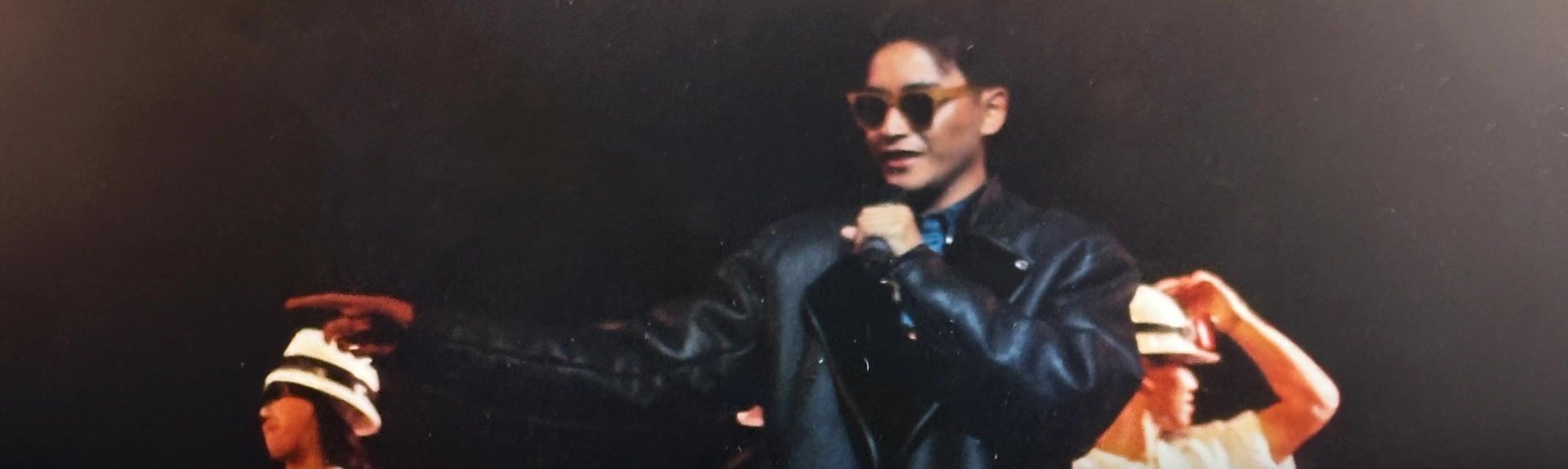 Archival performance footage of Leslie Cheung in dark sunglasses