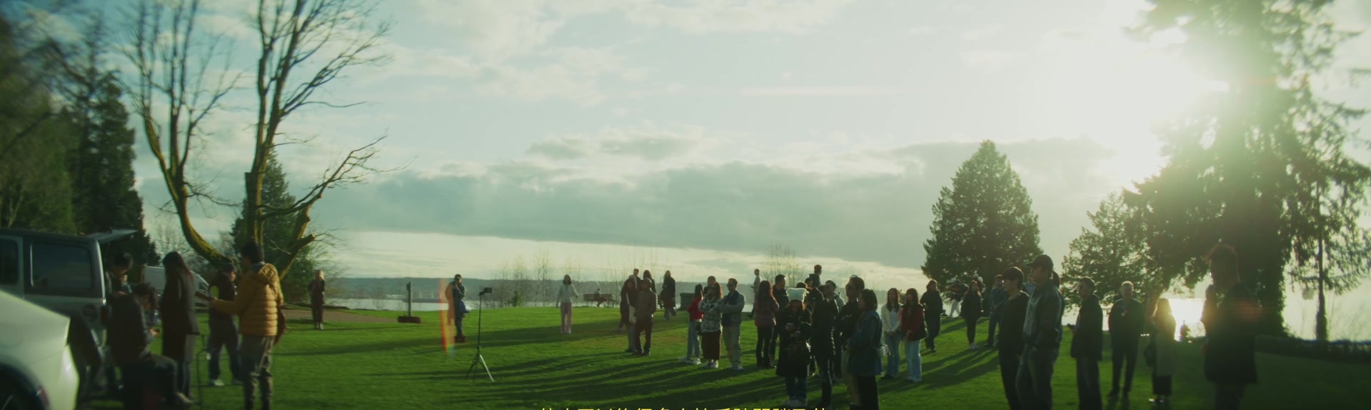 People gathering in a waterfront park to remember Leslie Cheung
