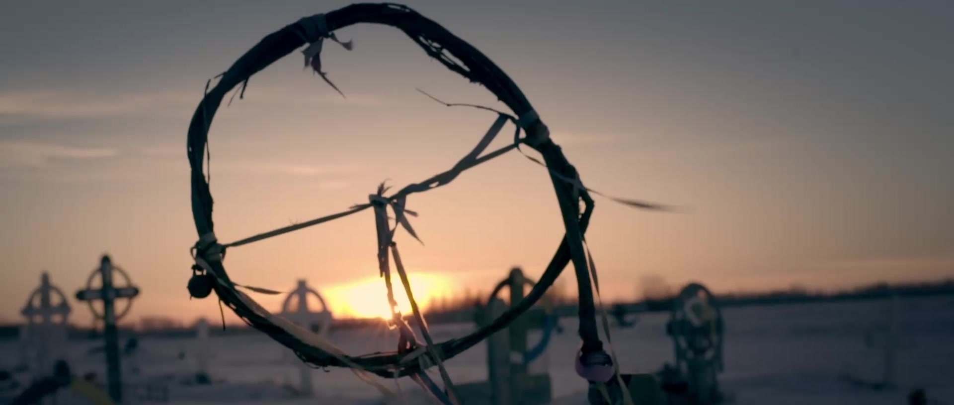 A circular structure silhouetted against the sunset