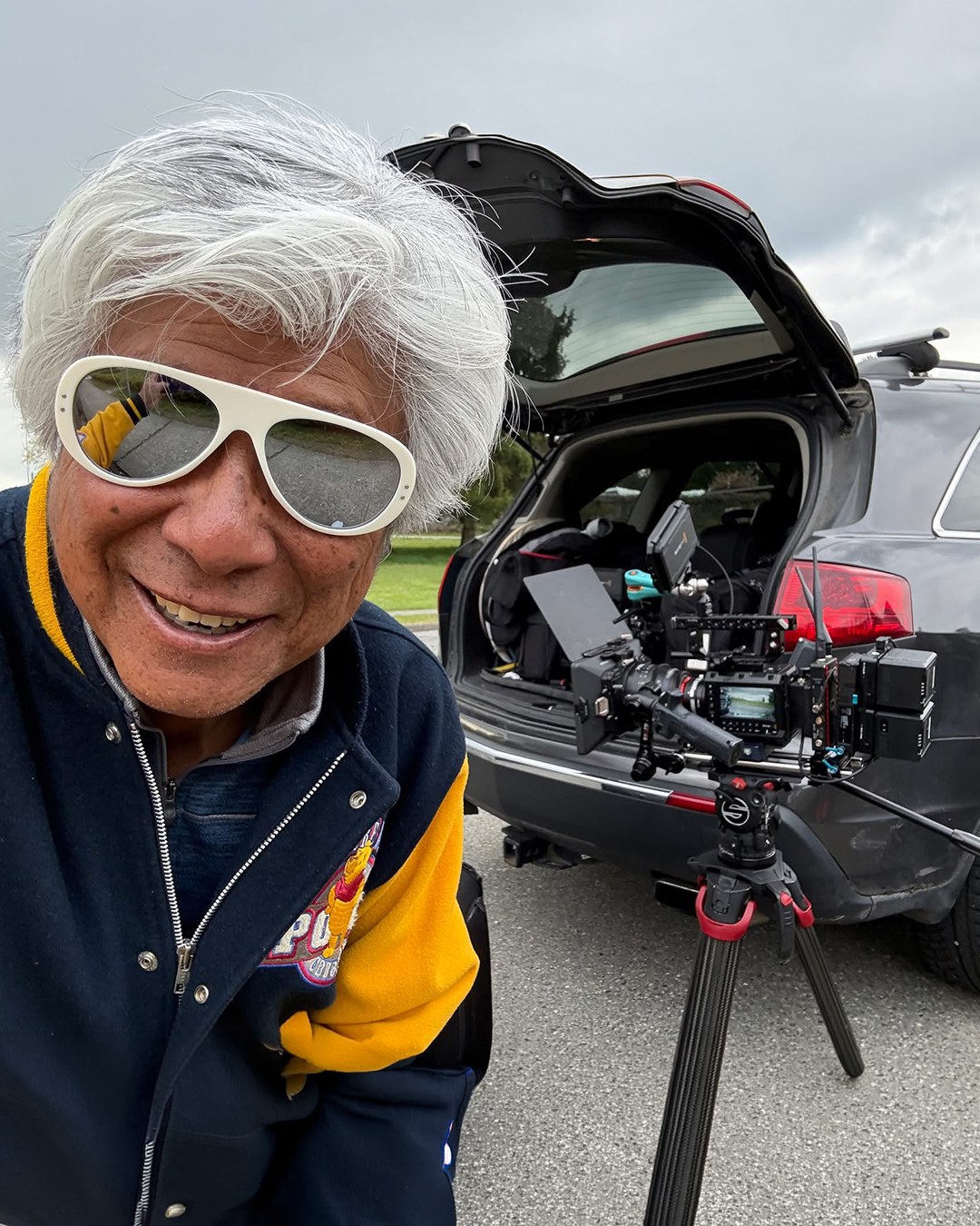 Wayne Wong smiling beside the production camera